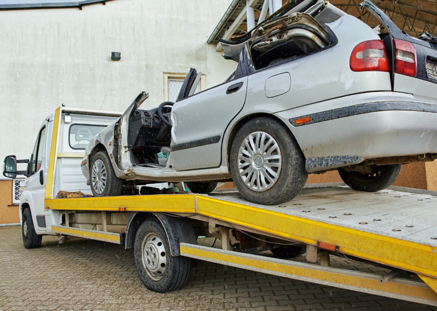 Damaged scrap vehicle loaded on a flatbed